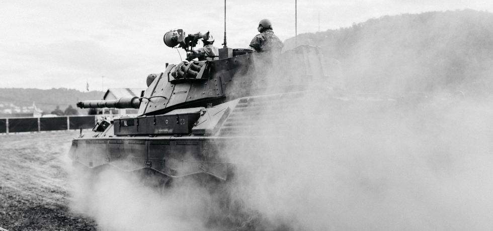 Grayscale photo of soldiers on a tank.