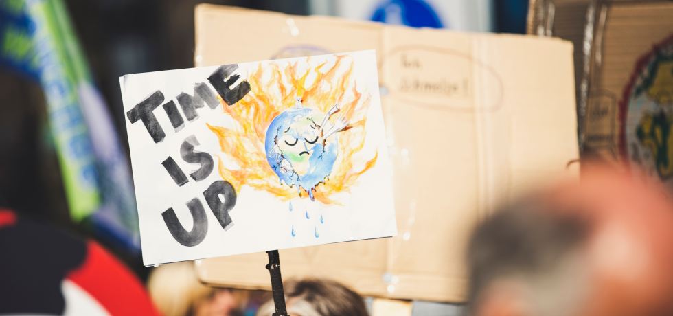 A sign at a climate protest that reads 'time is up'.