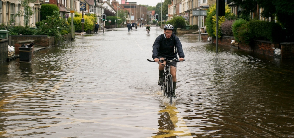 Person cycling through a flooded road